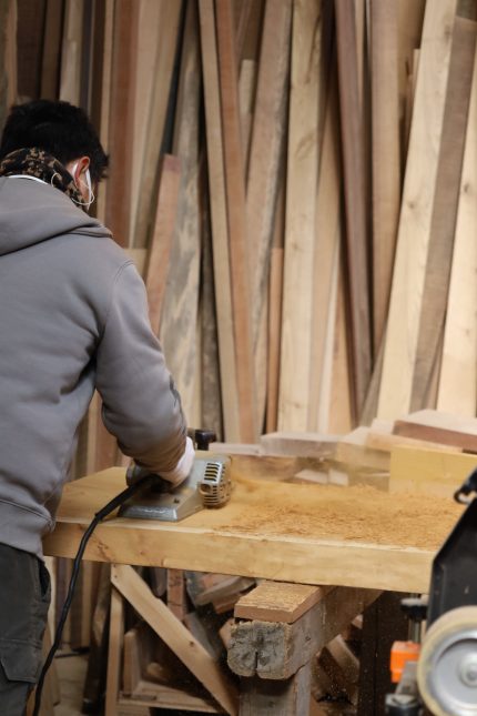 大きな無垢の一枚板と大工職人。